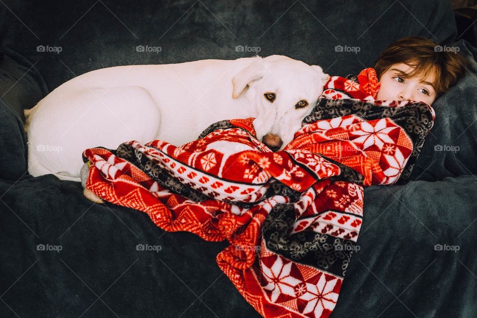 Big dog laying down on a child relaxing 