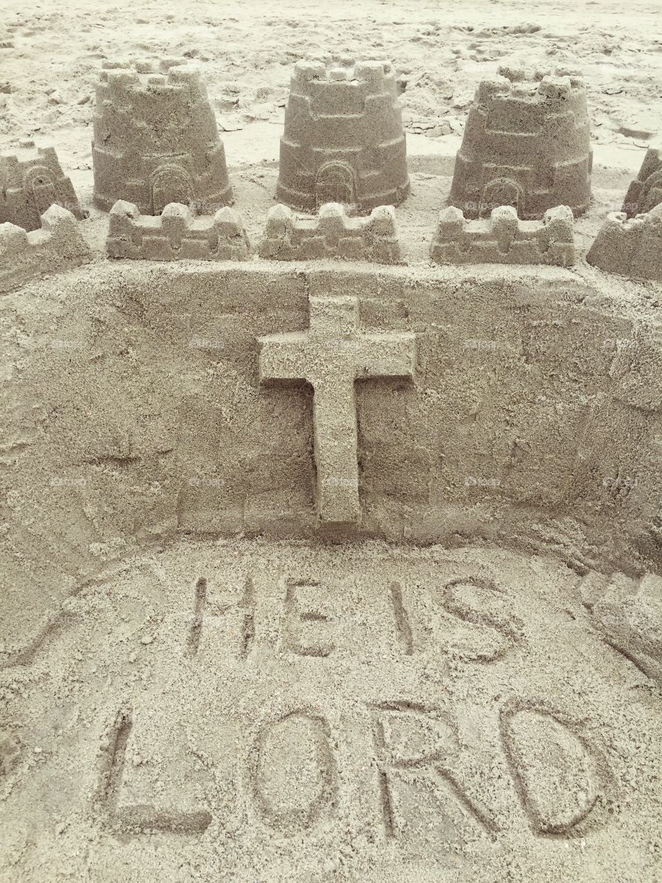 Sand Castle. A sand castle on the beach with a cross.