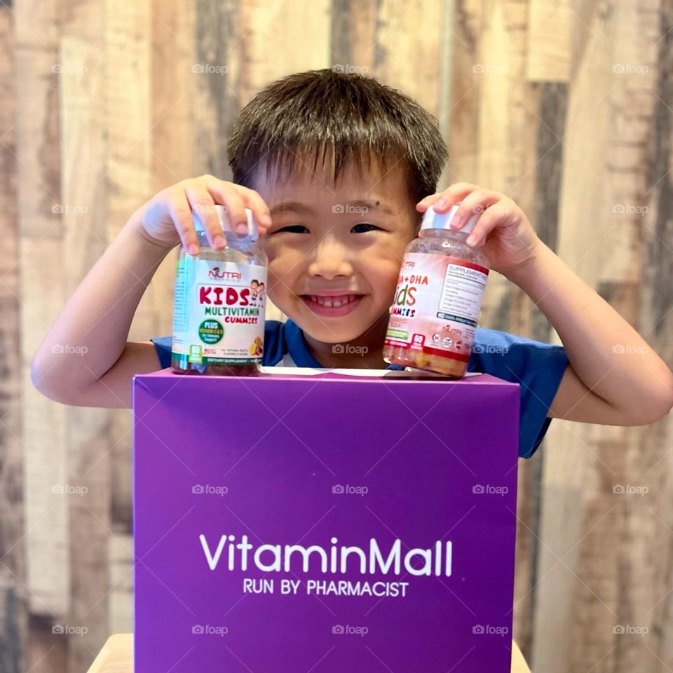 Happy asian kid with multivitamins gummies