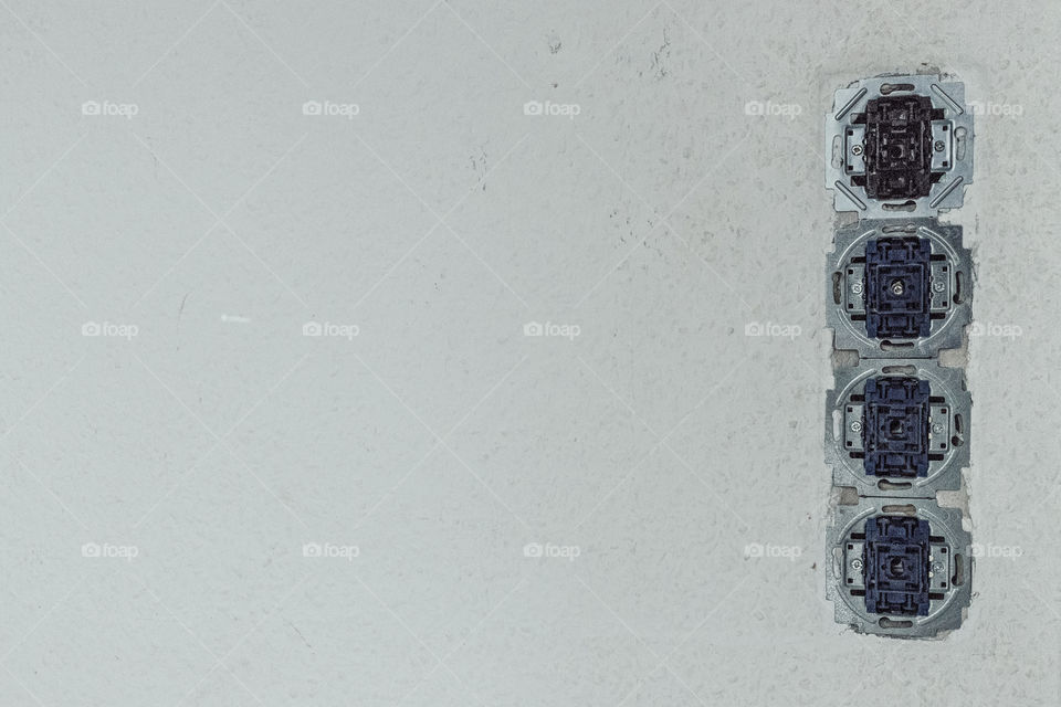 Renovate - Four light switches with no cover at a wall.