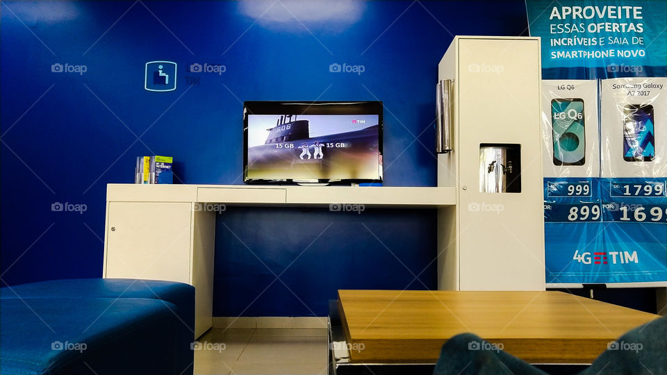 Sala, móveis, TV, parede azul.