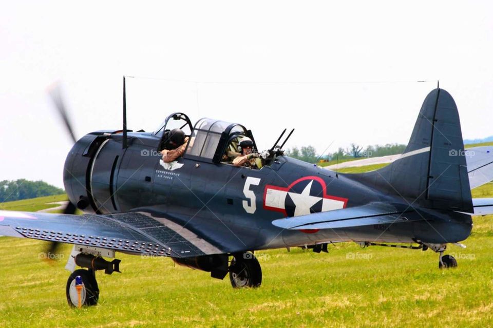 WWII battle reenactment warbird plane on takeoff, closeup of gunner and pilot