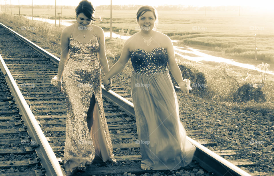 Female friends walking on empty rail track