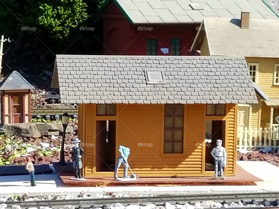 miniature headless man working along model train rail