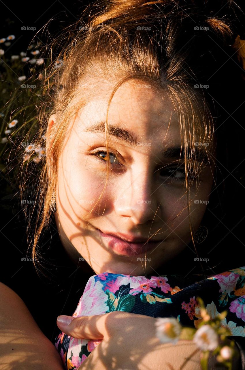 Close-up portrait of a girl. A girl with her hair tied up is caught in the light.
