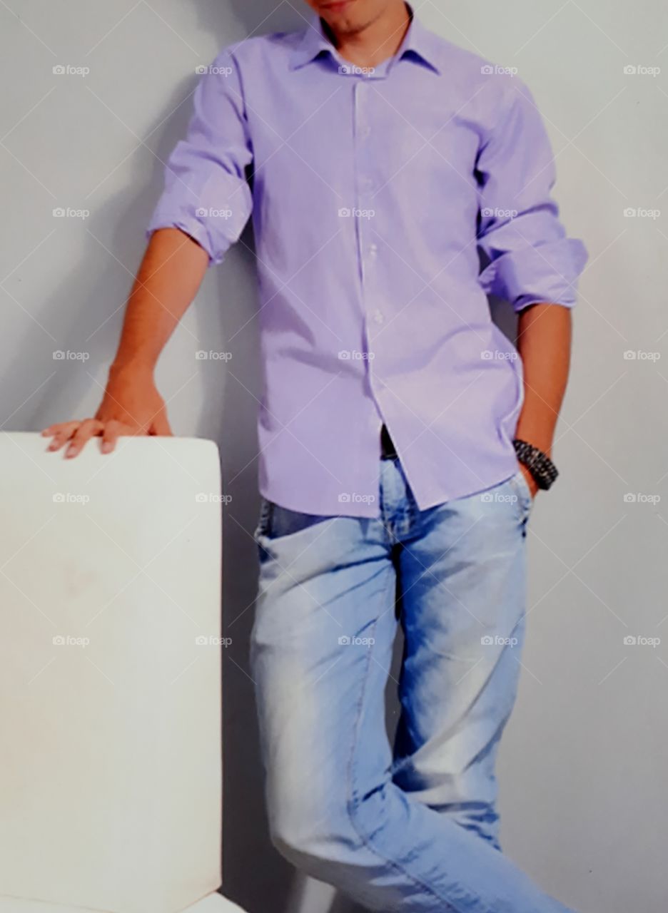 Young man dressed in purple shirt and jeans trousers