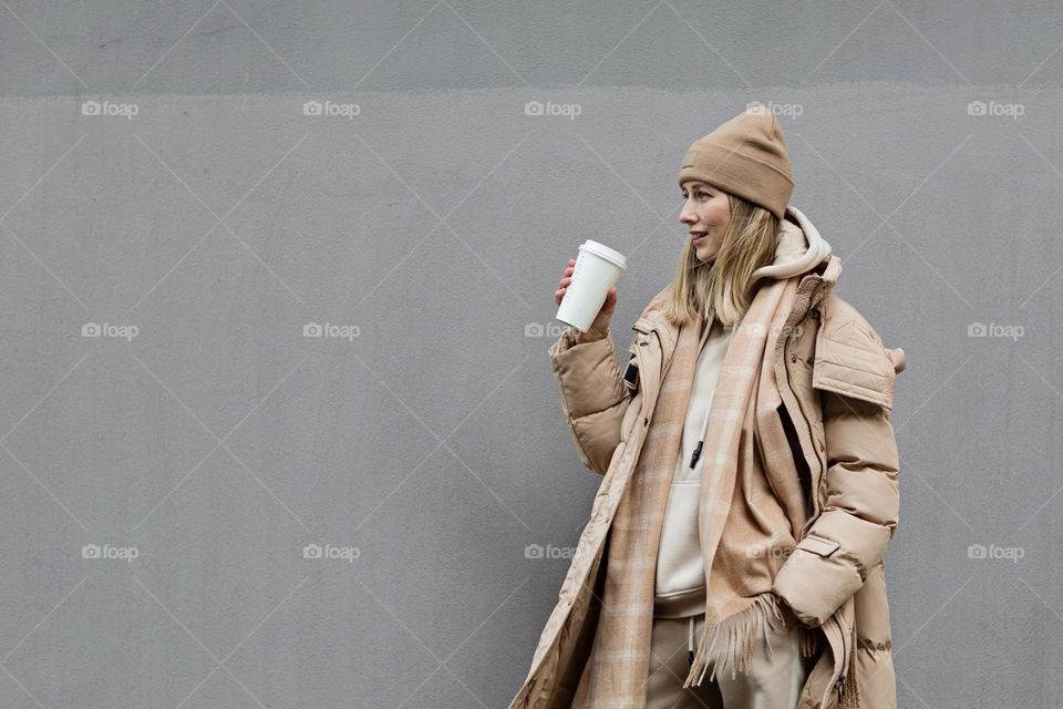 Woman drinks hot coffee outside 