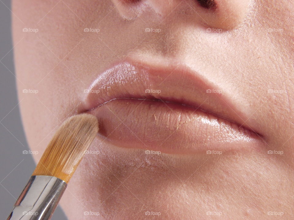 Woman makeup her lips.