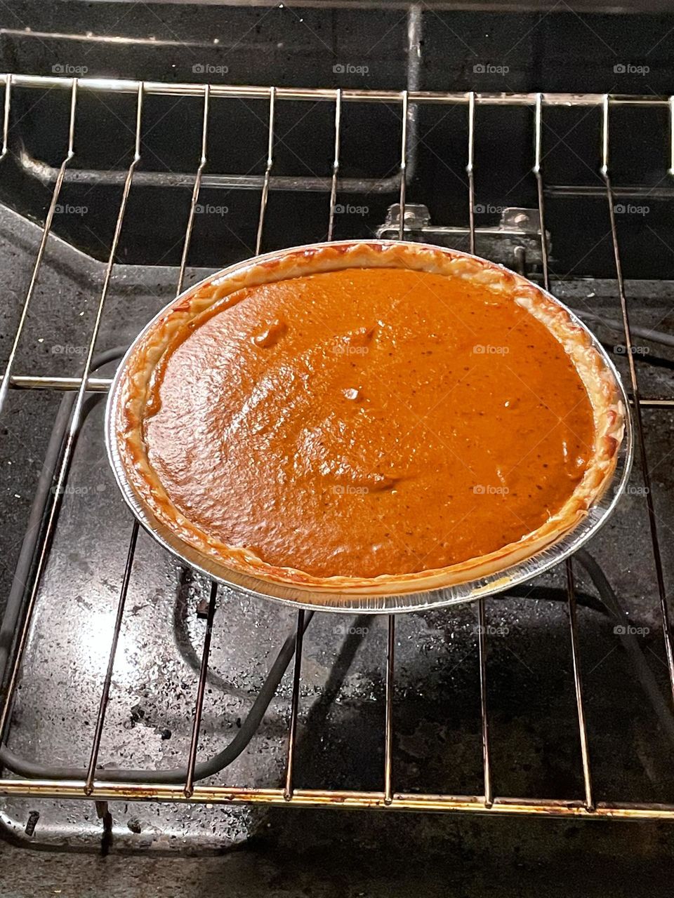 Baking delicious homemade pumpkin pie, in the oven and just about done
