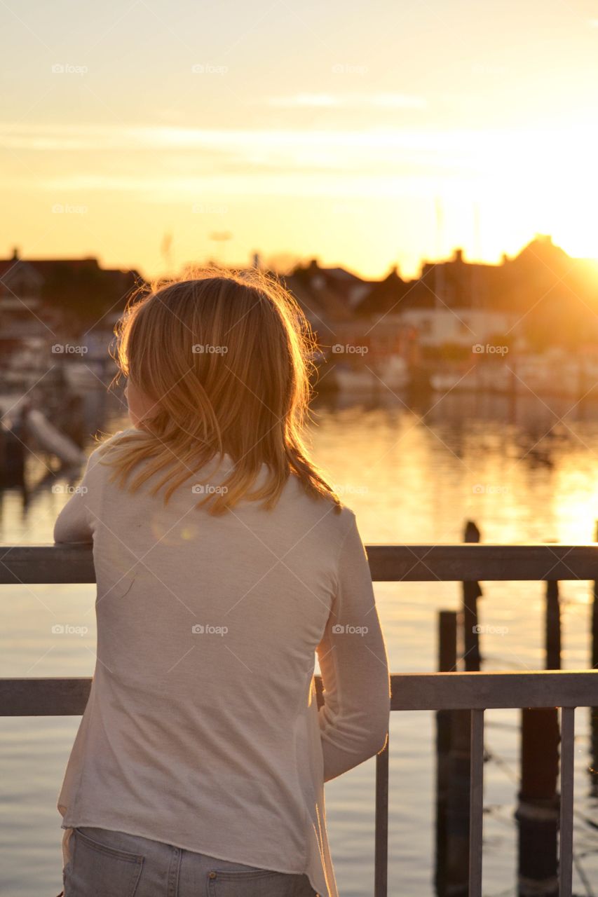 Girl looking out on the river during golden hour