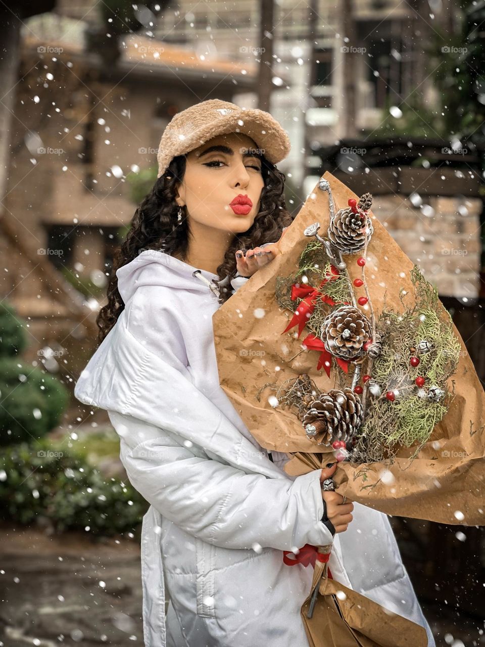 curly girl in snowy day with Bunch of pine flowers