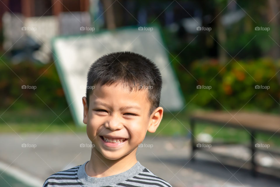 Portrait of a boy Asia, laughing and smiling happily in the park.