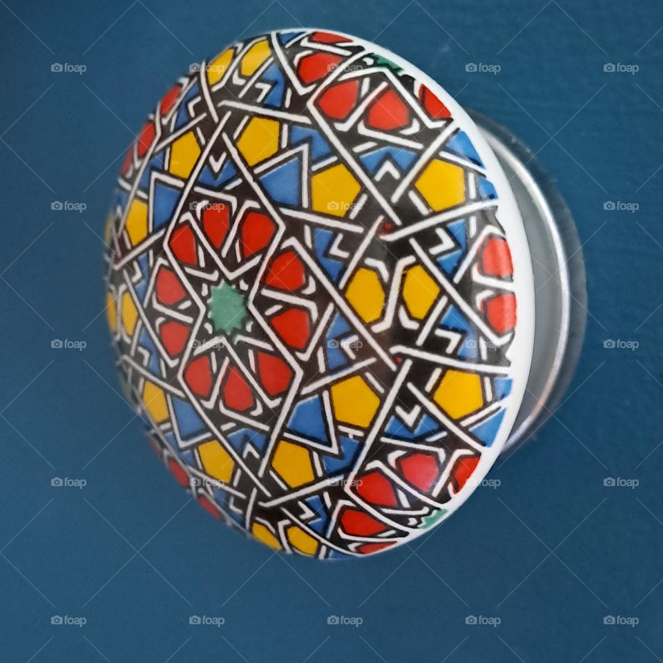 bright coloured door knob on draw. blue. patterned