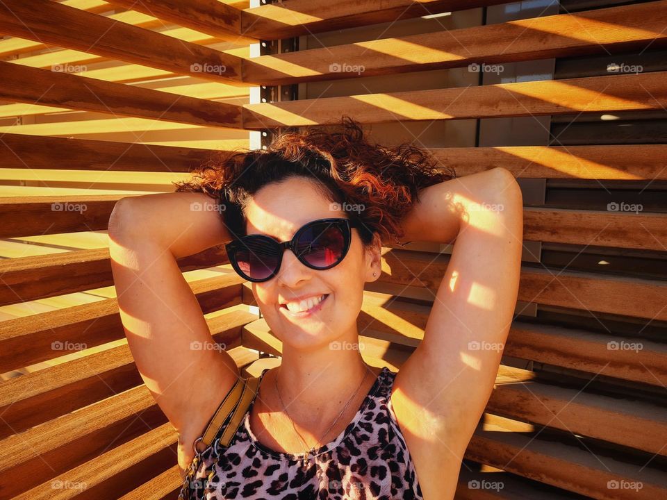 smiling woman touches her curly hair