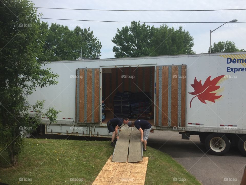 Two men workers in front of moving company truck