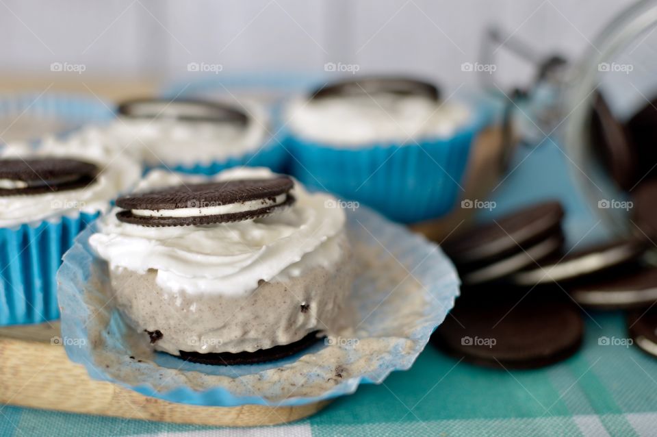 Oreo ice cream cups on a light blue and wooden background 