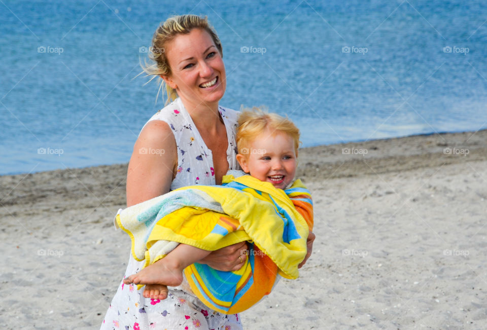 Close-up of a happy mother with her son on beach