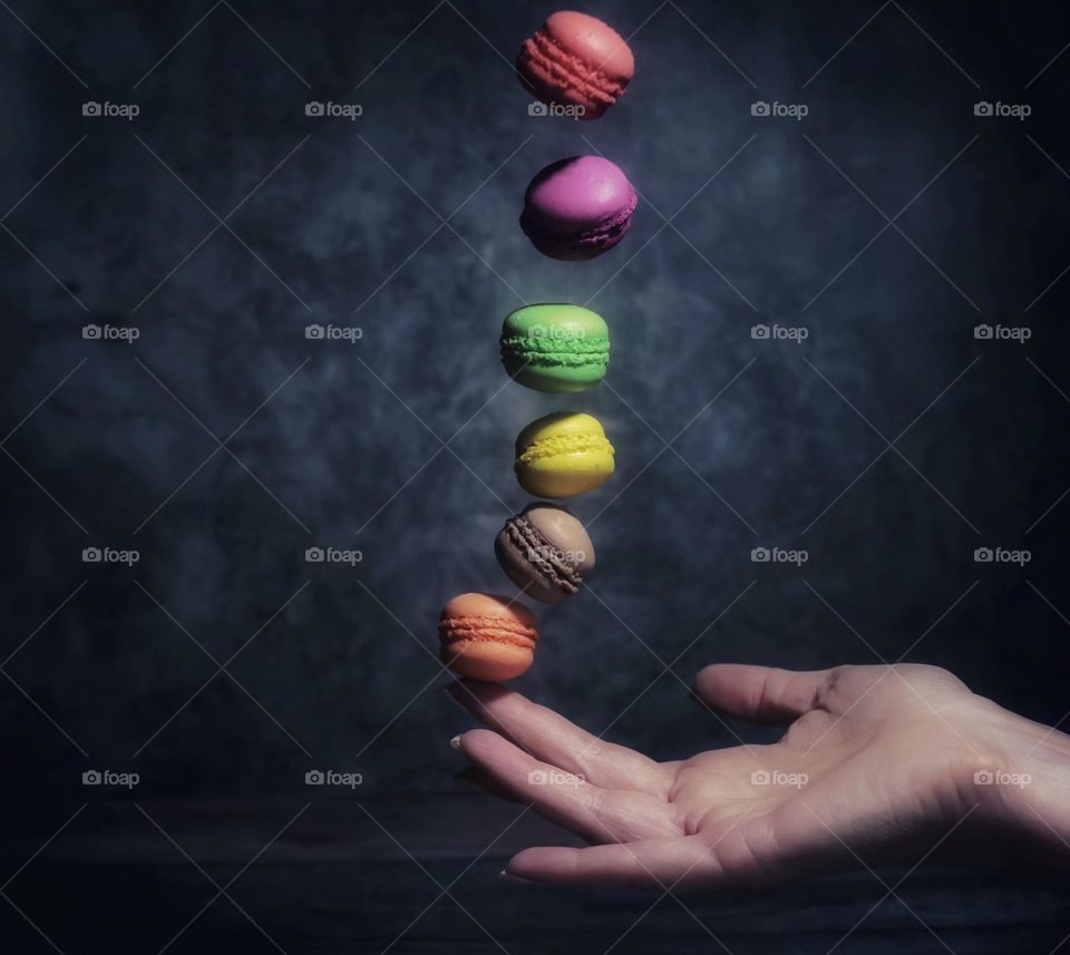 multi-colored cookies flying into the hand