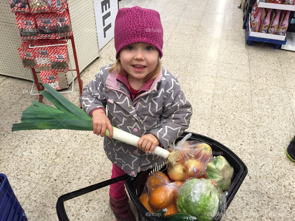 Little girl is helping put with the shopping in a local supermarket in Sweden.