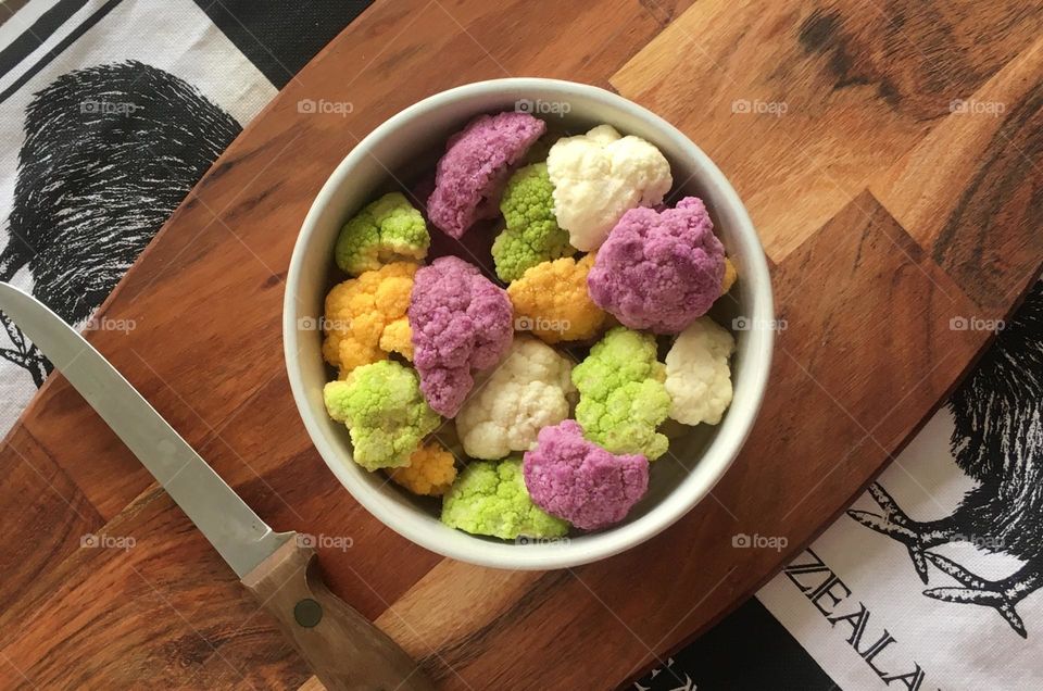 Bright and colourful cauliflower on a cutting board all ready to be cooked