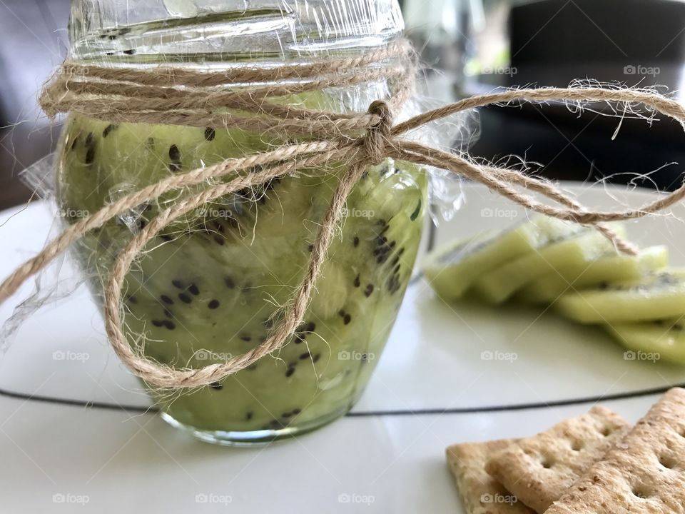 Homemade Kiwi jam and crackers on a plate 