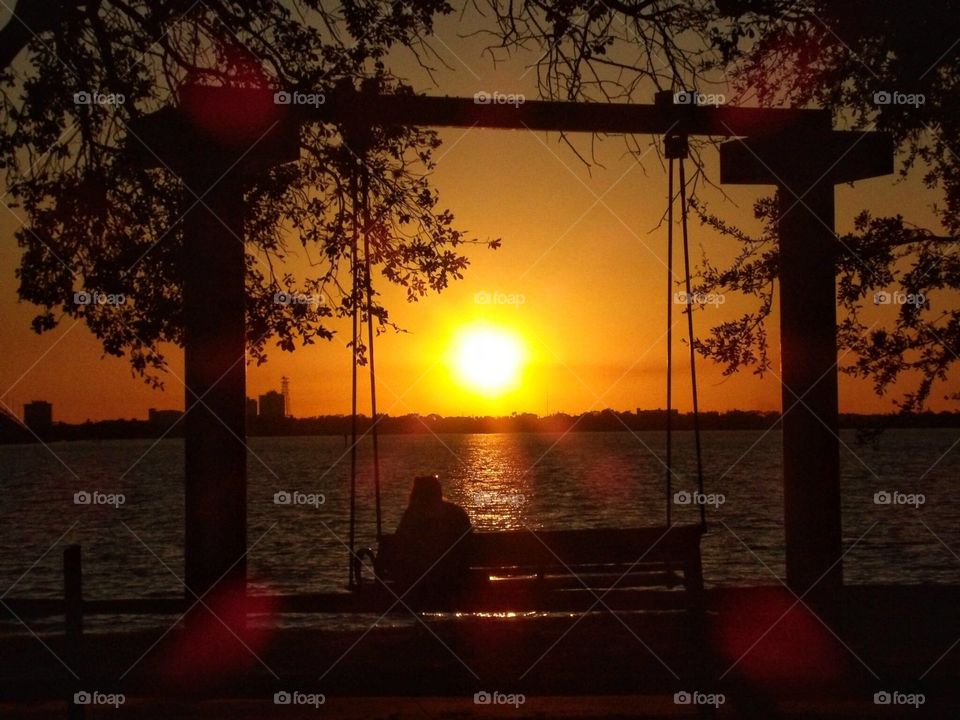 Silhouette of a person on swing