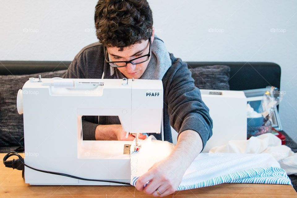 Man learning to sew