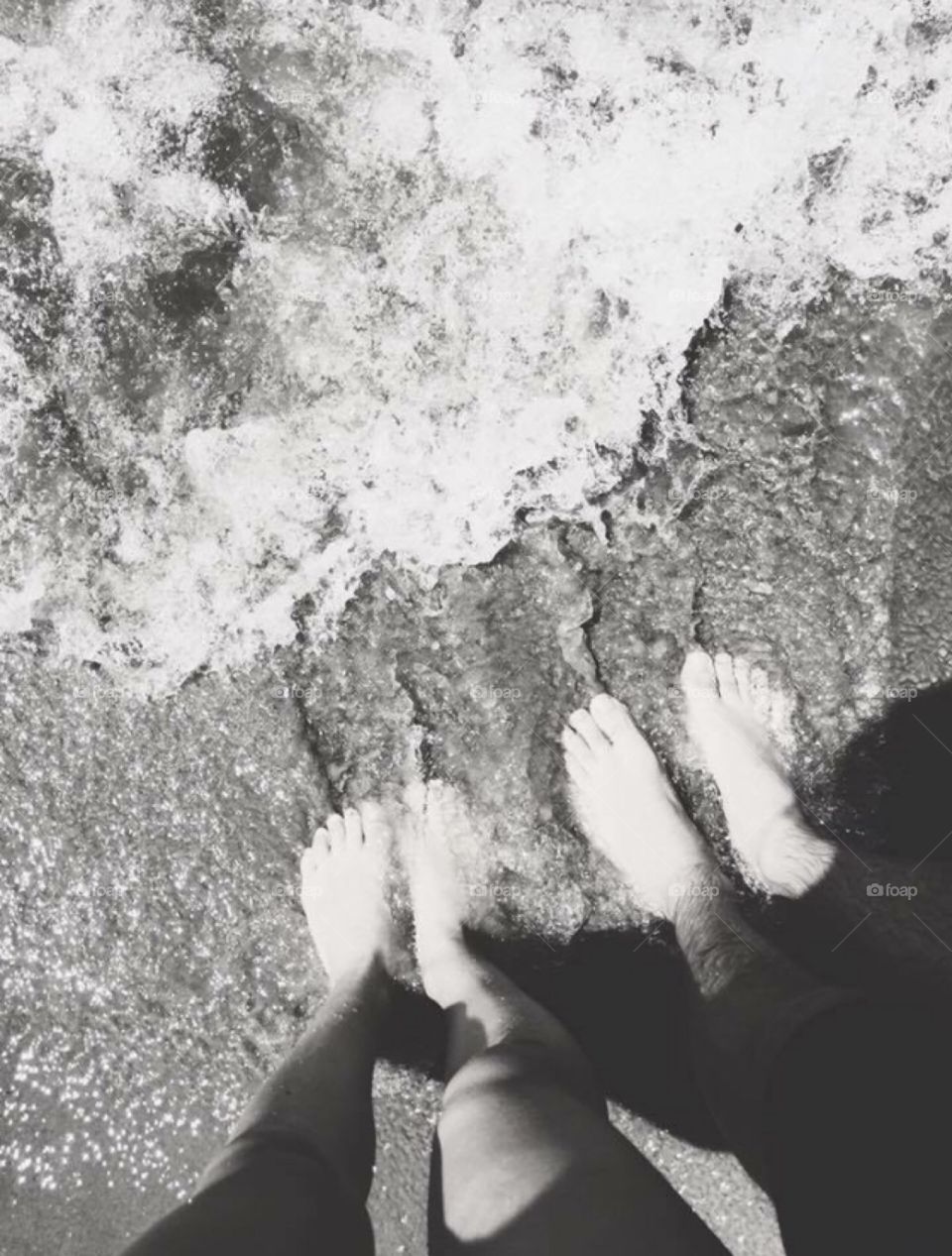 Couples feet in the water