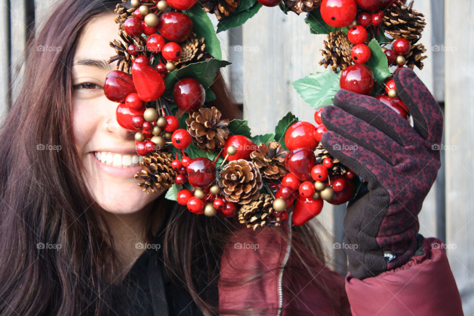 Happy smiling teen girl with winter festive decoration wreath