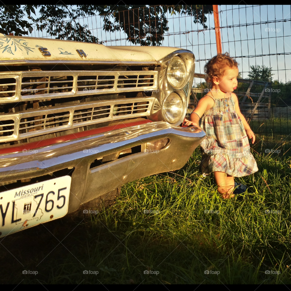 Cute girl standing near vintage car