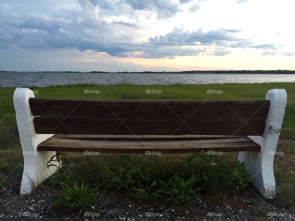 Contemplating bench over bay