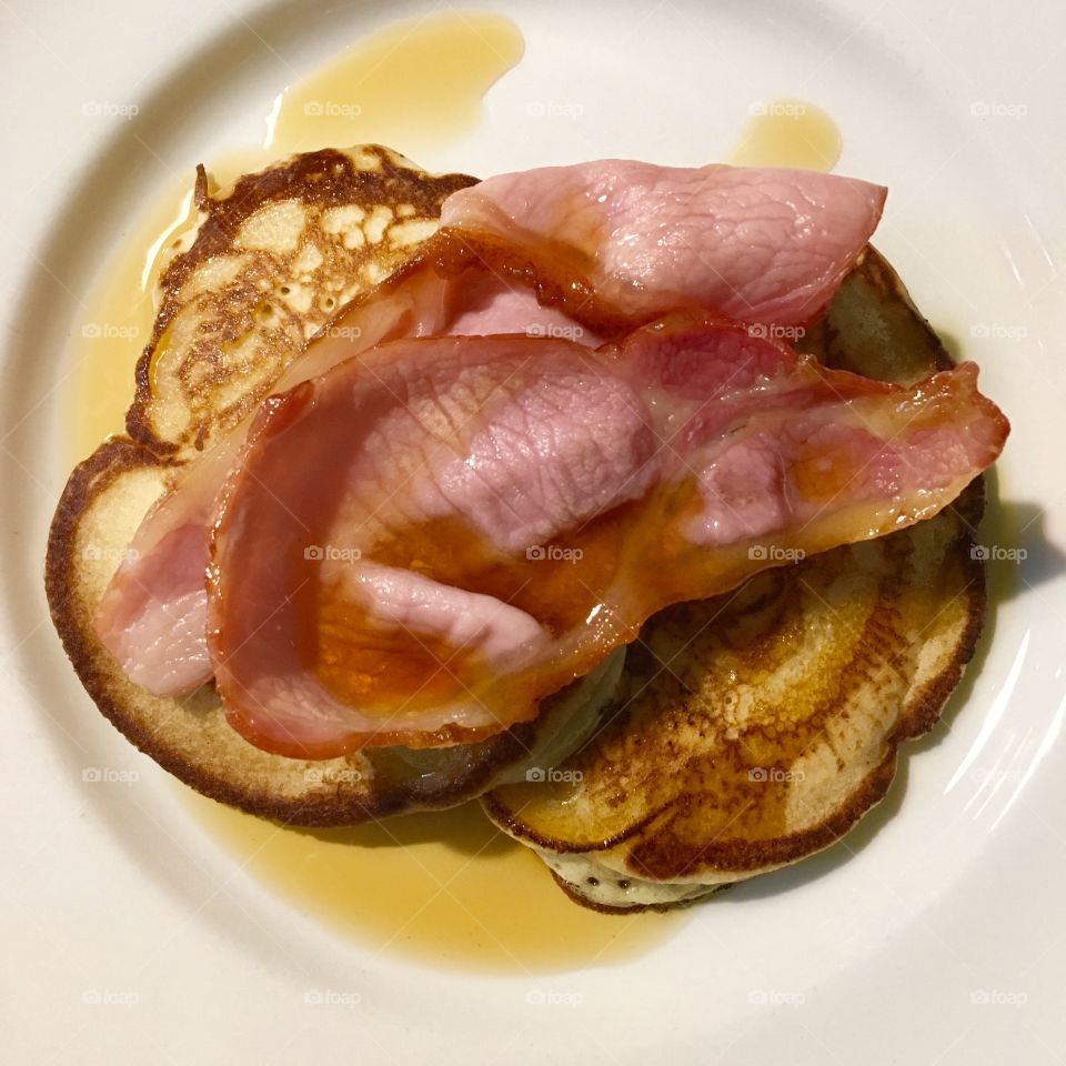 Fluffy homemade American pancakes with bacon and maple syrup