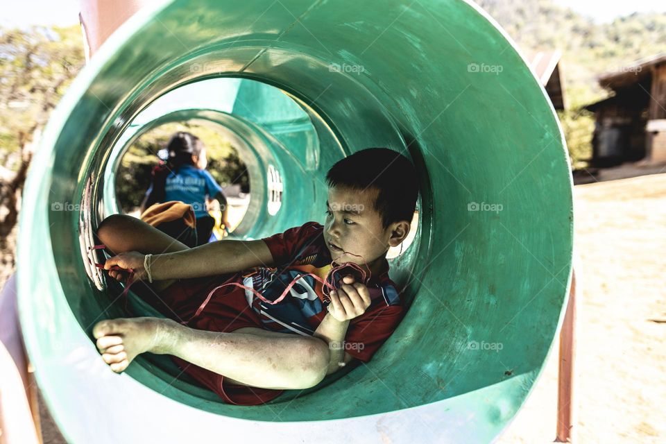 A boy playing in his tunnel tank at the school playground
