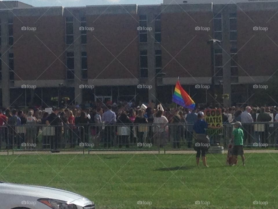 Westboro Baptist church members holding signs to protest an LGB club formed by students of IUPUI. Club supporters and spectators stand in the background.