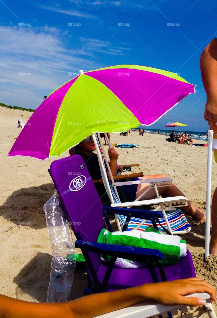 Sitting under an umbrella at the beach