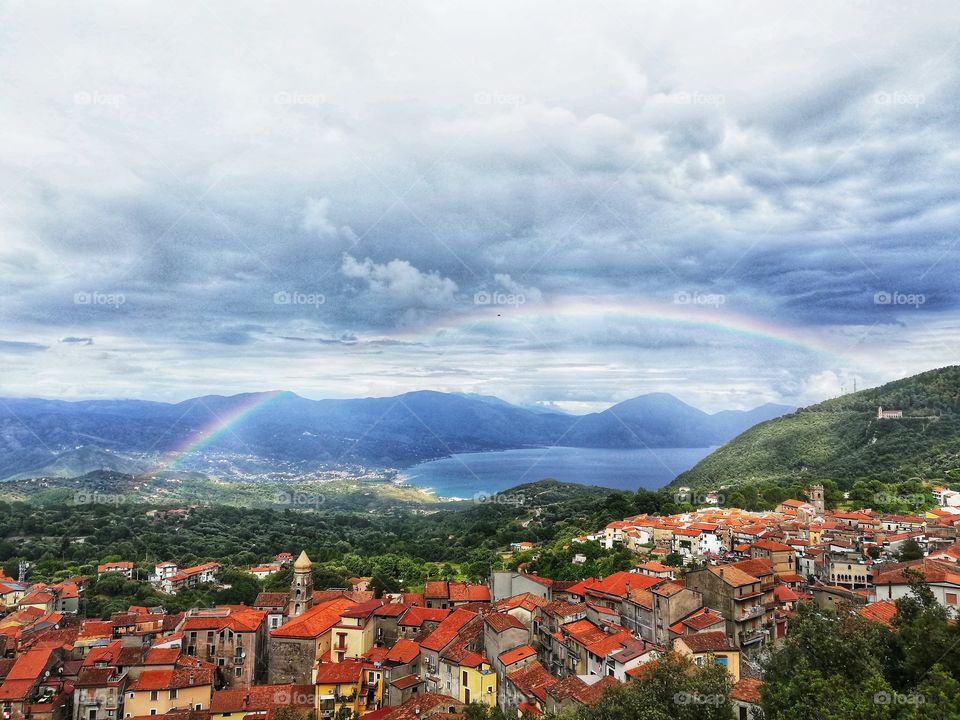 view of San Giovanni a Piro, a picturesque town in Cilento (Italy) surrounded by clouds and a rainbow