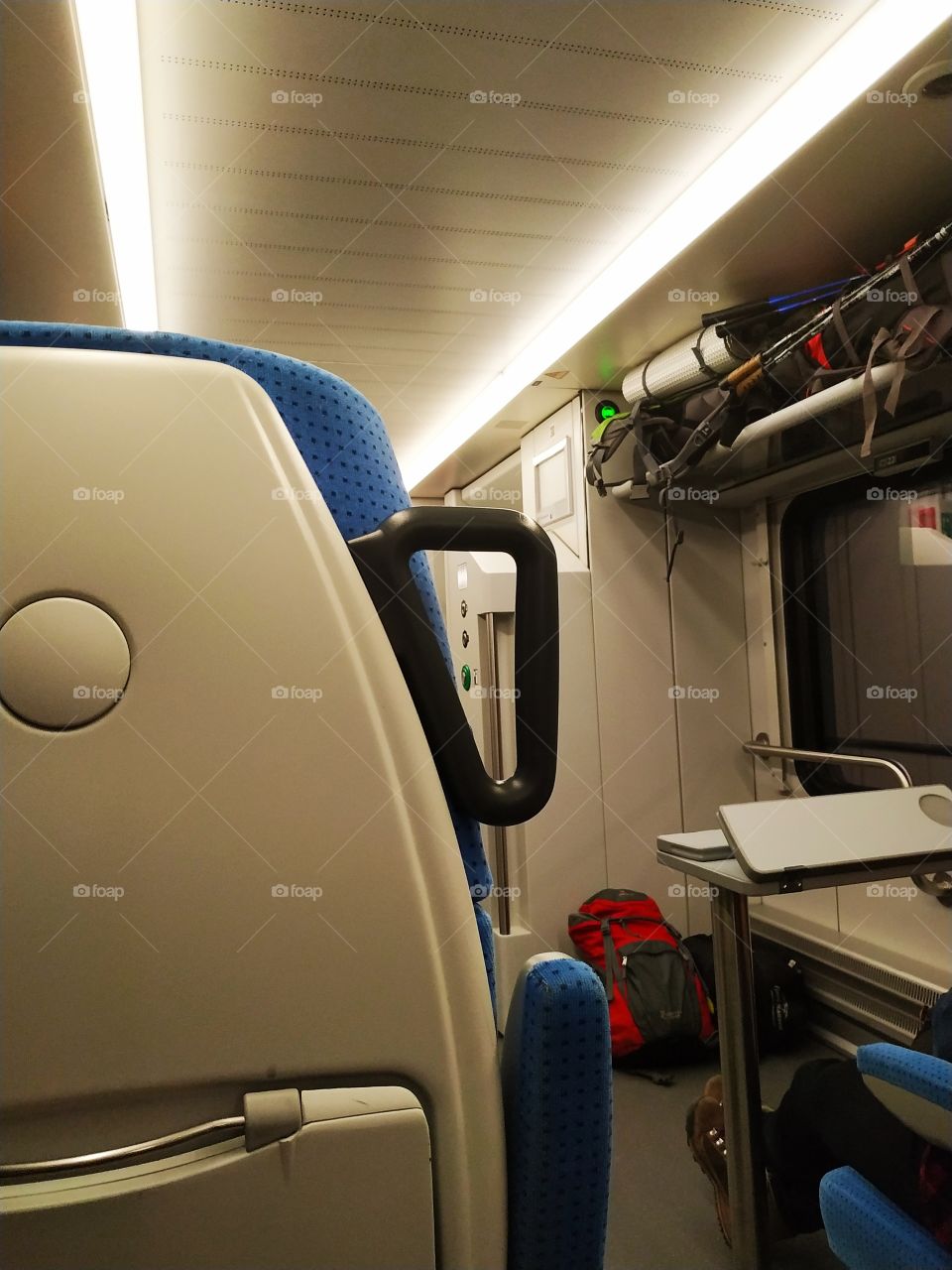 Bright interior of a modern train. Climbing equipment on a shelf.