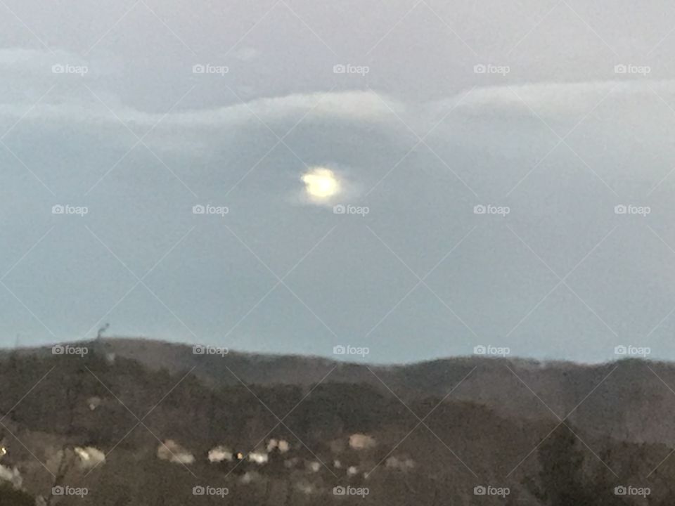Obscured moon over mountains 