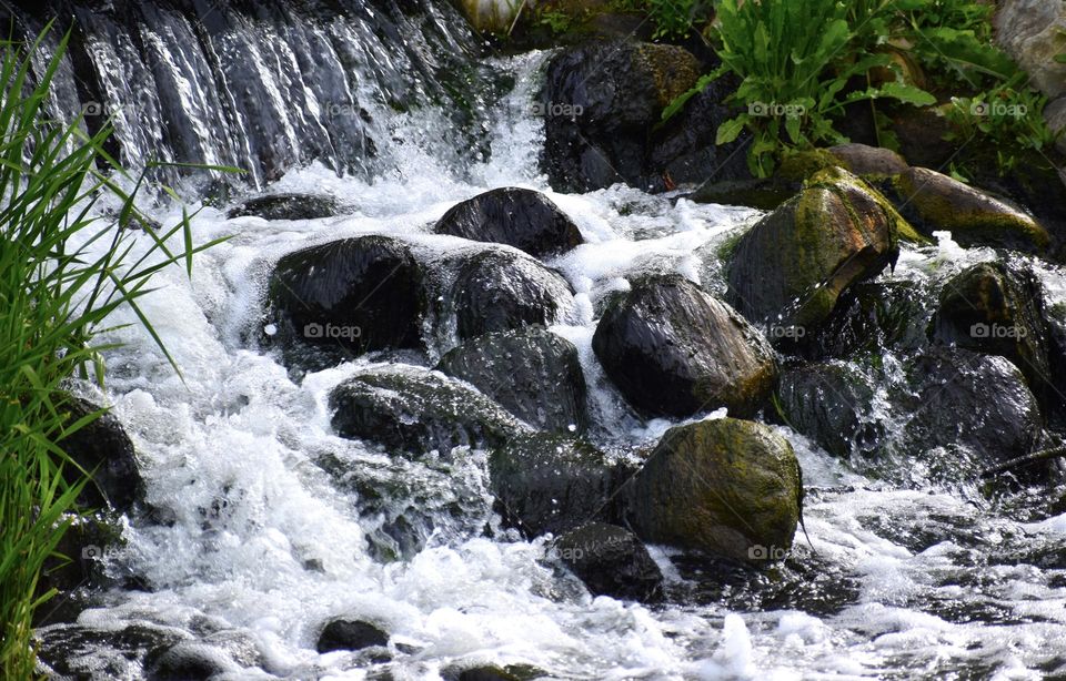 Water falls over smooth rocks