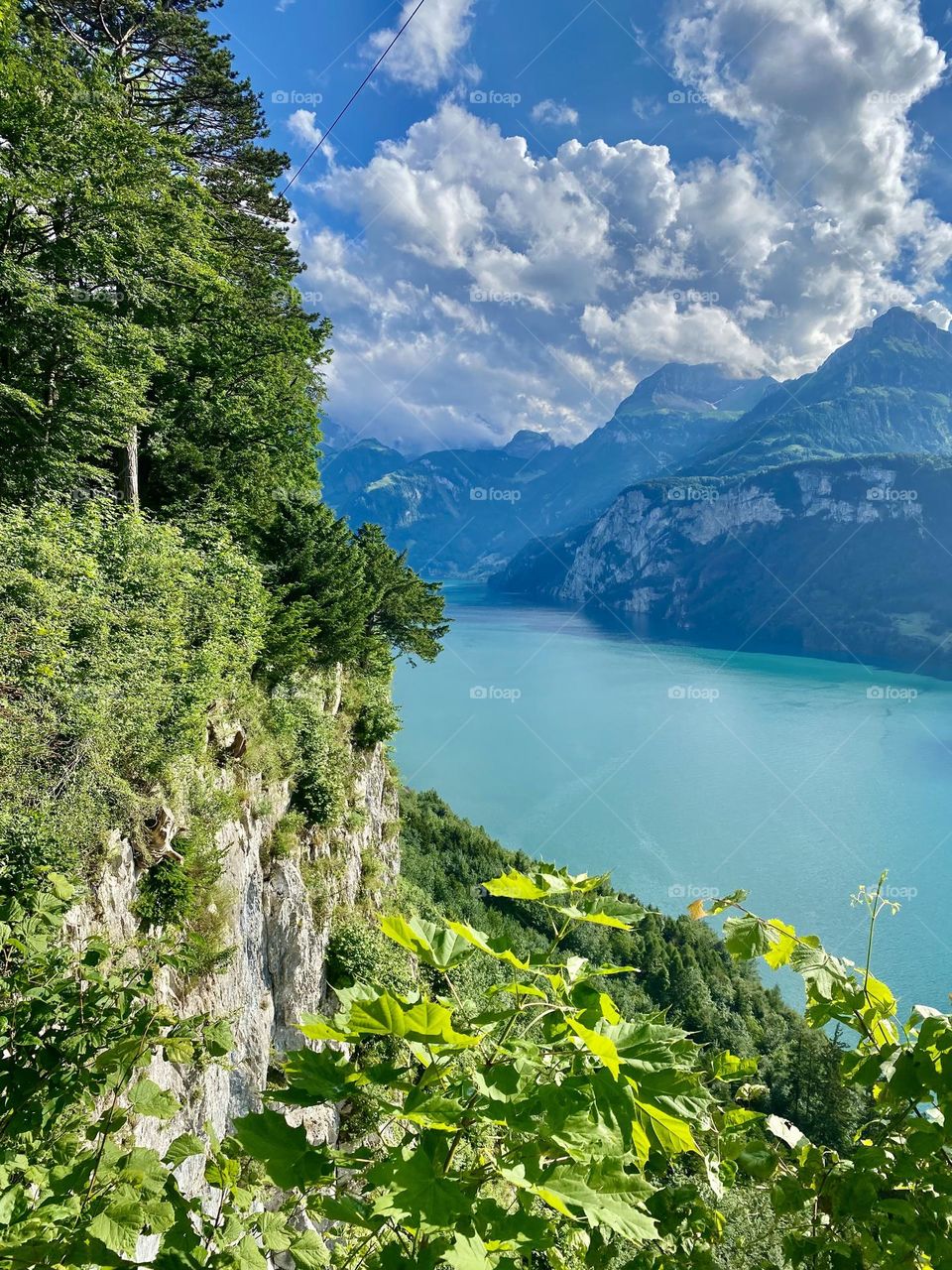 photo from above of a beautiful landscape in switzerland, mountains, lake, rocks, trees
