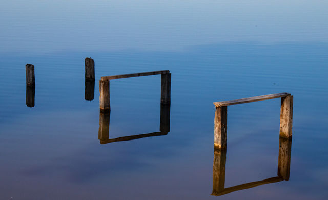 Lago em interior de São Paulo mostrando reflexo de madeira.