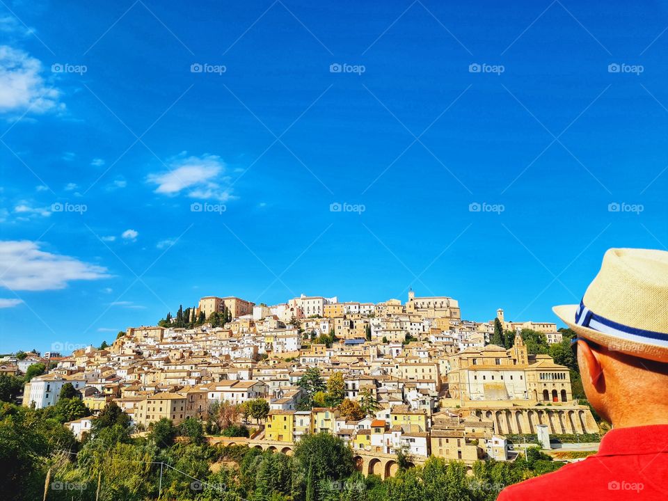 man from behind looks at a town in Abruzzo: Loreto Aprutino