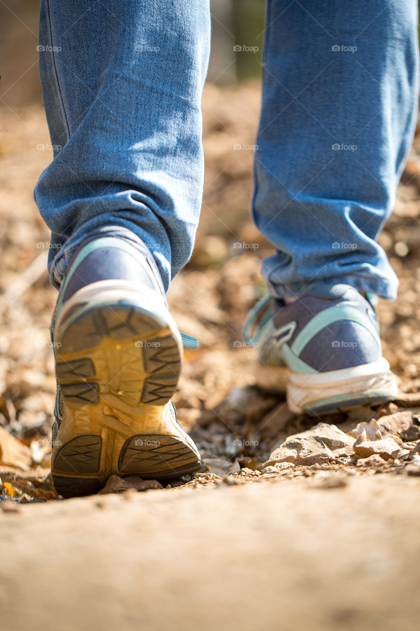 My daily routine includes walking daily. Image of closeup of person walking showing shoes