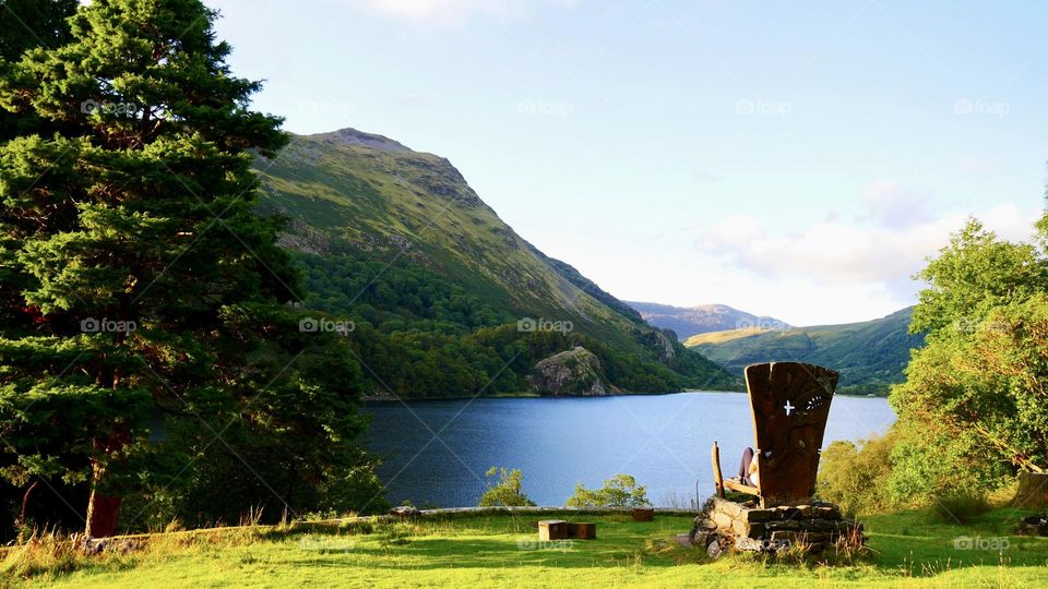 Big wooden craft chair viewing lake and mountains 