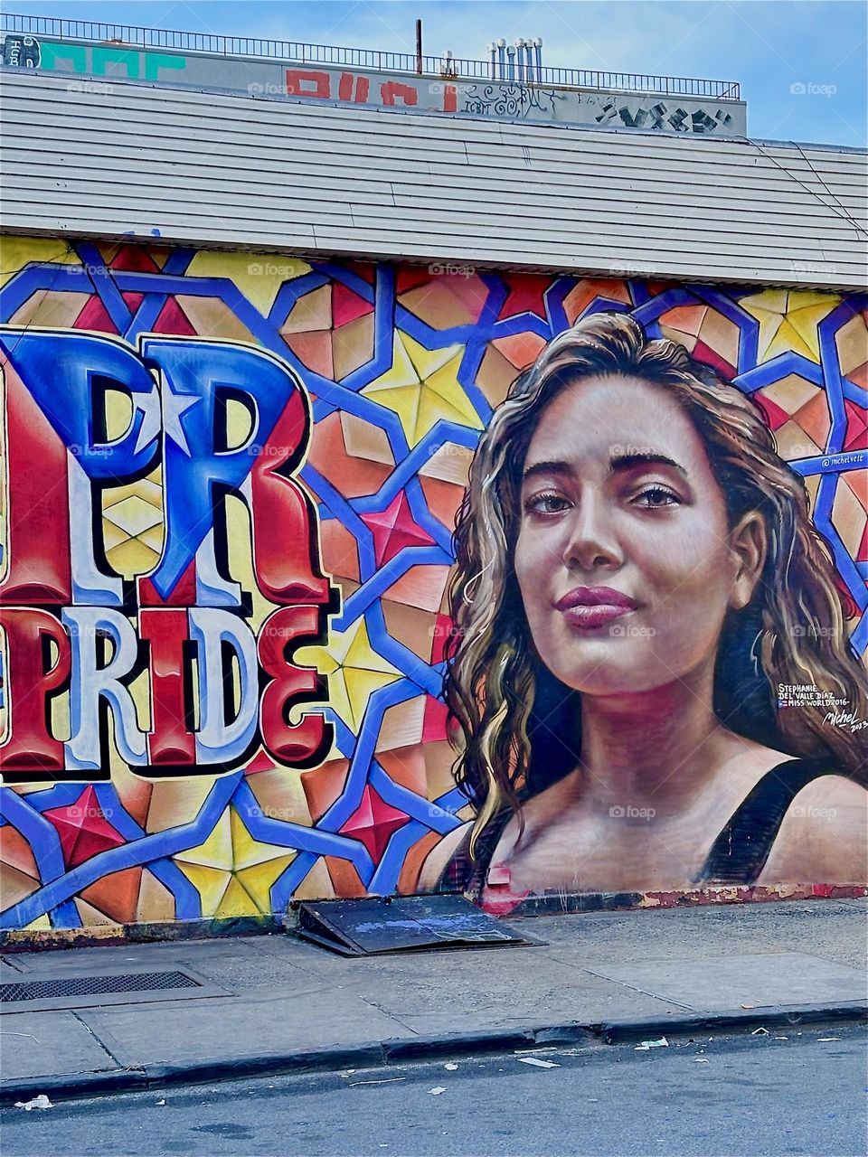 The word „PRIDE“ is spelled out next to the portrait of a young Latin woman from NYC on an art mural on „Jefferson Street“ off „Broadway“ in „Bushwick“, Brooklyn. 2024. Hypnotic Productions