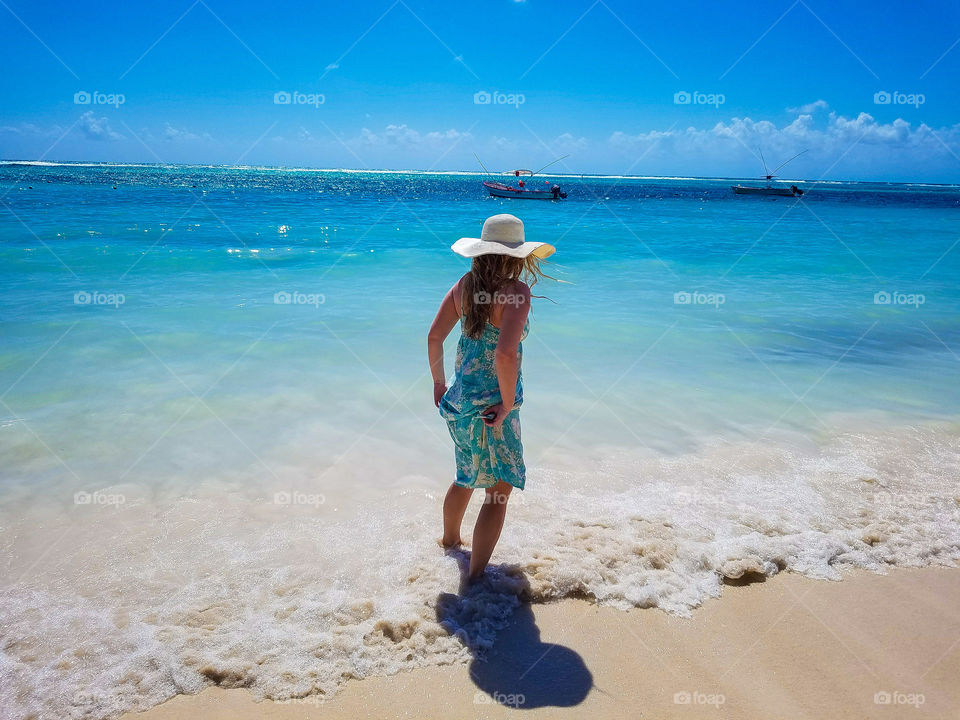 A woman standing on sandy beach