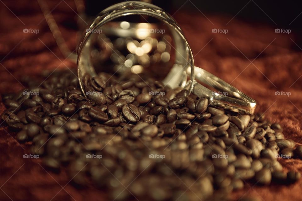Fragrant coffee beans are scattered on a red background. Roasted coffee beans close up.