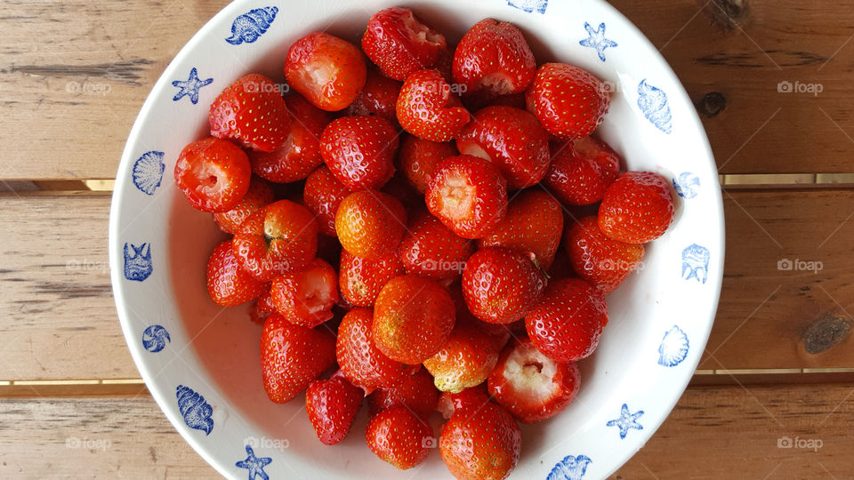 Strawberries in white bowl on table
