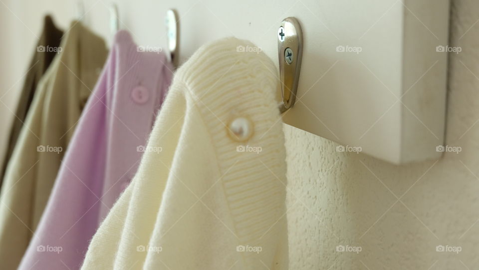 Sweaters hanging on hook