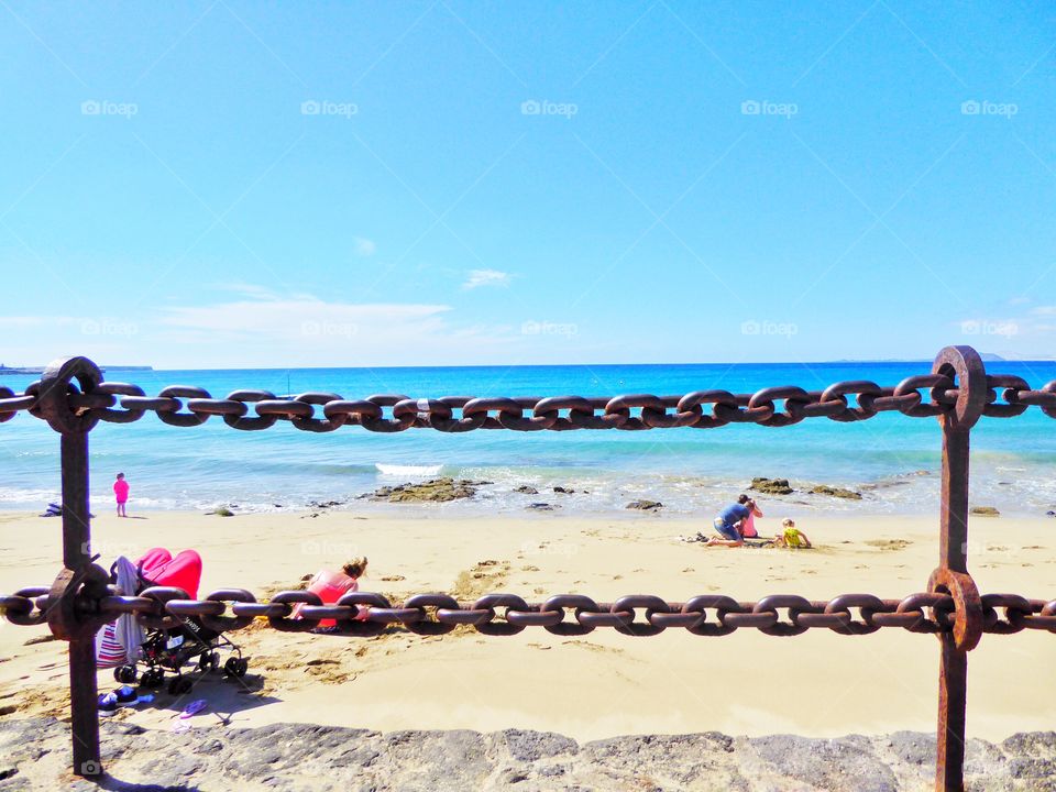 View of idyllic beach and chain railing